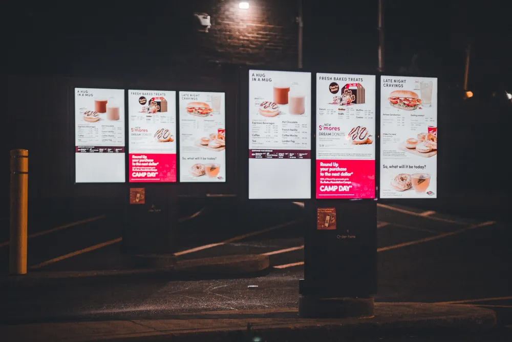 Painéis de LED digitais exibindo cardápio em fachada comercial
